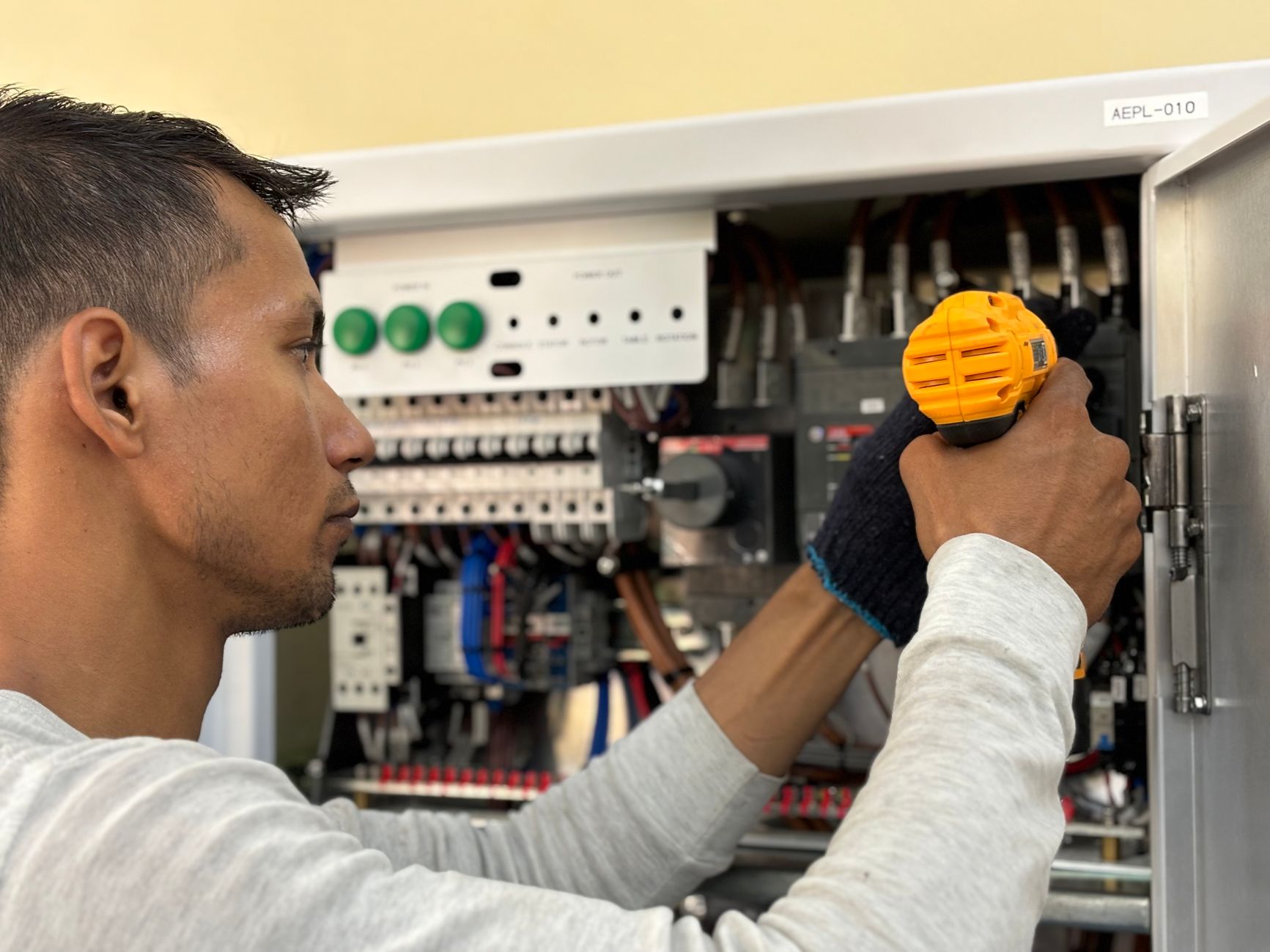Elektriker skruer en afbryder fast i tavle